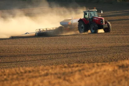 Imagem mostra um trator trabalhando em um campo. Agricultura e cultivo de fazendas industriais.