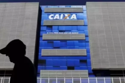 Silhueta de pedestre na frente de prédio da Caixa.