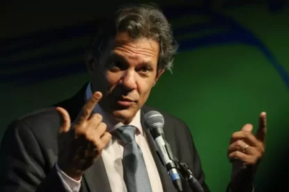 Ministro Fernando Haddad gesticula de terno durante fala.