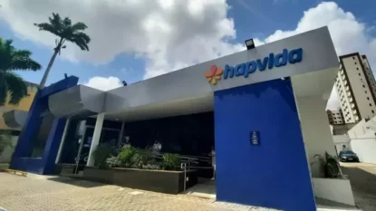 Fachada da entrada de loja da Hapvida em um dia de céu azul, entre nuvens