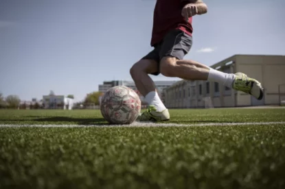 Homem de vista lateral jogando futebol.