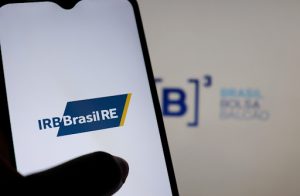 A imagem mostra um smartphone na tela do IRB Brasil RE, e serve para ilustrar a matéria que fala sobre as quedas do Ibovespa.