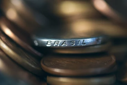 Detalhe de moeda de real, com a inscrição "Brasil". Imagem remete a investimentos em renda fixa, especialmente no Tesouro Direto.