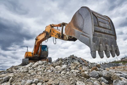 Máquina escavadeira trabalha em canteiro de obras de mineração. (Imagem: Kadmy em Adobe Stock)