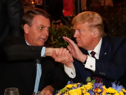 Donald Trump e Jair Bolsonaro se cumprimentam; americano condicionou revogação de tarifas a anistia a ex-presidente brasileiro.