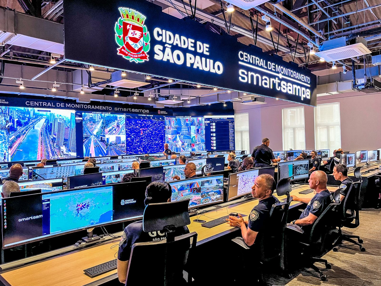 Operadores trabalham na central de monitoramento do Smart Sampa, sistema da Prefeitura de São Paulo que integra câmeras de vigilância e tecnologias de reconhecimento facial para apoiar ações de segurança pública.